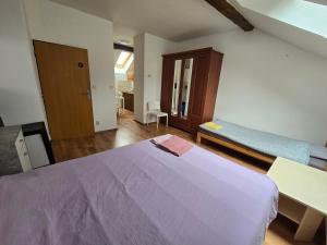 um quarto com uma grande cama roxa e um banco em Apartments Žižkov a em Praga