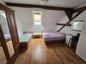 um pequeno quarto com 2 camas num sótão em Apartments Žižkov a em Praga