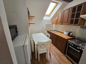 uma pequena cozinha com uma mesa branca e um fogão em Apartments Žižkov a em Praga
