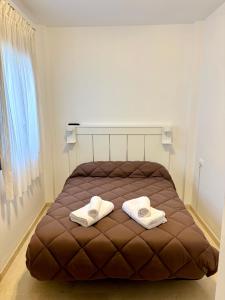 a bedroom with a brown bed with towels on it at Apartamento Espinel 47 in Ronda