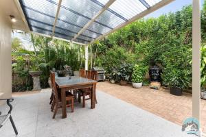 a patio with a table and chairs under a pergola at Aircabin - Blakehurst - Spacious - 5 Beds House in Sydney
