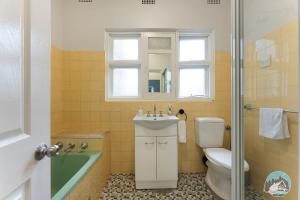 a bathroom with a sink and a toilet and a shower at Aircabin - Blakehurst - Spacious - 5 Beds House in Sydney +21 photos