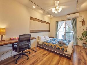 a bedroom with a bed and a desk and a chair at Yukurina Resort Okinawa in Motobu