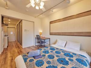 a bedroom with a bed and a desk in it at Yukurina Resort Okinawa in Motobu