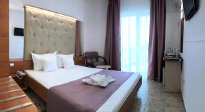 a hotel room with a bed with a flower on it at Complex Modern All Inclusive in Mamaia