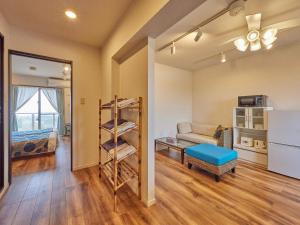 a living room with a couch and a refrigerator at Yukurina Resort Okinawa in Motobu