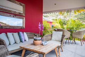 een patio met een bank, stoelen en een tafel bij Quinta da Tia Briosa by Madeira Sun Travel in Ponta do Sol