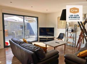 ein Wohnzimmer mit einem Ledersofa und einem Tisch in der Unterkunft Appartement climatisé avec sa terrasse de 25 M2 in Limoges