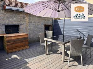 einen Tisch und Stühle auf einer Terrasse mit einem Sonnenschirm in der Unterkunft Appartement climatisé avec sa terrasse de 25 M2 in Limoges