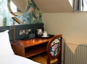 a bedroom with a desk with a mirror and a bed at Narborough Arms in Narborough
