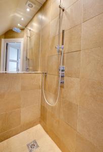 a bathroom with a shower with a glass door at Garden Stable Cosy Stone Cottage with Parking in Alnmouth +27 photos