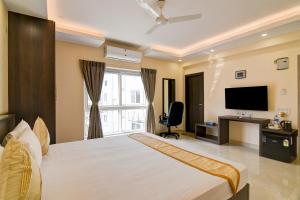 a bedroom with a large bed and a television at AVS Prime in kolkata