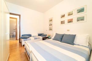 a white bedroom with two beds and a mirror at Lunas Apartment by Wonderful Italy in Bellagio