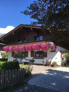 dom z różowymi kwiatami na boku w obiekcie Haus Elisabeth Schwaiger w mieście Maria Alm am Steinernen Meer