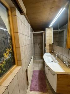 W łazience znajduje się wanna, umywalka i lustro. w obiekcie Haus Elisabeth Schwaiger w mieście Maria Alm am Steinernen Meer