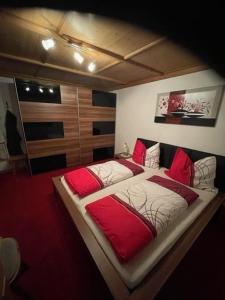 sypialnia z dużym łóżkiem z czerwonymi poduszkami w obiekcie Haus Elisabeth Schwaiger w mieście Maria Alm am Steinernen Meer