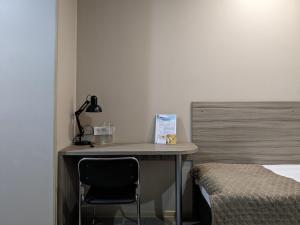 ウラリスクにあるVictoria Hotelのデスク(ランプ付)、ベッド横の椅子