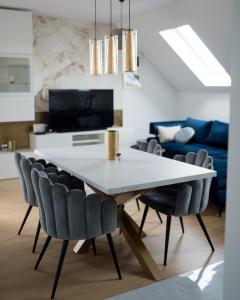 a dining room with a white table and chairs at Apartman “Manhattan” in Križevci