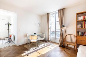 a dining room with a table and chairs and a window at GuestReady - Sunlit Serenity near Montmartre in Paris