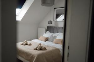1 dormitorio con 1 cama con 2 toallas en Apartman “Manhattan”, en Križevci