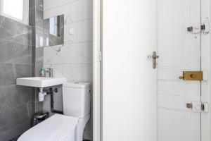 a white bathroom with a toilet and a sink at GuestReady - Sunlit Serenity near Montmartre in Paris