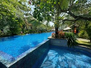 - une piscine d'eau bleue dans un complexe dans l'établissement Villa Đà Nẵng Gần Biển - Biệt Thự Đà Nẵng, à Đà Nẵng
