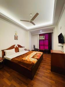 a bedroom with a large bed and a ceiling fan at HOTEL PLAZA GRAND in Jalandhar