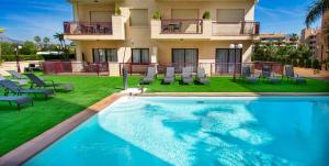 a villa with a swimming pool in front of a house at Apartamentos Albir Confort - Avenida 1 dorm in Albir