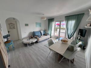 una sala de estar con un sofá y una mesa en Apartamento con jardín privado en Menorca, en Cala'n Porter