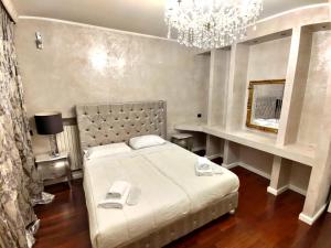 een slaapkamer met een groot wit bed en een kroonluchter bij Villa Eleganza Milano Bergamo Airport in Dalmine