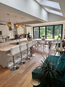 a kitchen and living room with tables and chairs at Room with balcony overlooking a garden in London