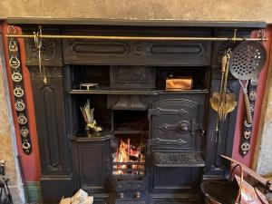 a black fireplace with a fire in it at Victorian Copper Cottage in Lancaster