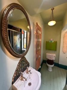 a bathroom with a sink and a mirror at Victorian Copper Cottage in Lancaster