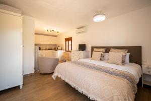 a bedroom with a large bed and a kitchen at Casa Amarilla Casitas in Alhaurín el Grande