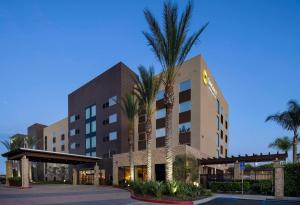 a hotel with a palm tree in front of it at SunCoast Hotel Anaheim, Tapestry Collection by Hilton in Anaheim