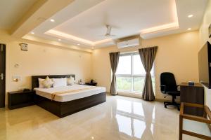 a bedroom with a bed and a desk and a window at AVS Prime in kolkata