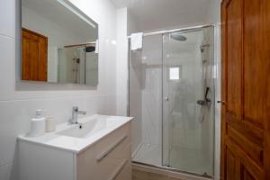 a white bathroom with a shower and a sink at Casa Amarilla Casitas in Alhaurín el Grande +6 photos