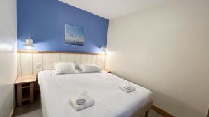 1 dormitorio con cama blanca y pared azul en Argousiers 111 en Fort-Mahon-Plage