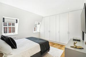 um quarto branco com uma cama e uma secretária em 4 bedroom home by Buckingham Palace em Londres