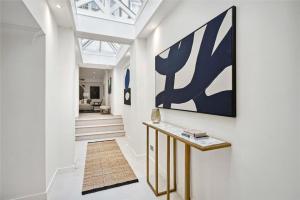 a hallway with a large painting on the wall at 4 bedroom home by Buckingham Palace in London