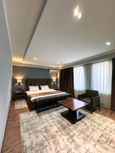 um quarto de hotel com uma cama e uma mesa em Ziyorat Luxury em Fergana