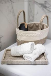 a pair of towels on a wooden tray with a basket at A night at the Museum in Athens