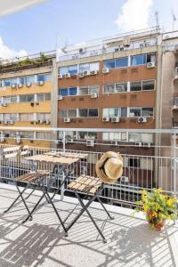 un cappello e sedie su un balcone con un edificio di A night at the Museum ad Atene