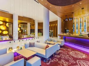 a lobby with couches and tables and a bar at Swissotel Tallinn in Tallinn