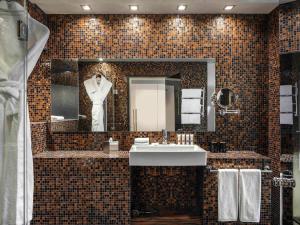 a bathroom with a sink and a mannequin in a mirror at Swissotel Tallinn in Tallinn