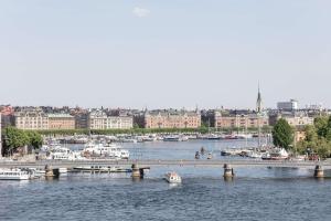 a bridge over a river with boats in a city at Hôtel Reisen in The Unbound Collection by Hyatt in Stockholm