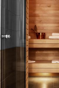 um chuveiro na casa de banho com paredes de madeira em Hôtel Reisen in The Unbound Collection by Hyatt em Estocolmo