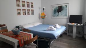 1 dormitorio con cama, mesa y TV en RiDi Home Zona Ospedaliera, en Nápoles