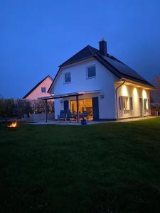 una casa blanca con luces en un patio por la noche en Ferienhaus Paula en Marlow