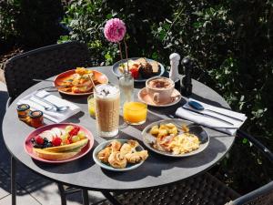 a table with plates of breakfast food on it at The 1932 Hotel & Spa Cap d'Antibes - MGallery Collection in Juan-les-Pins